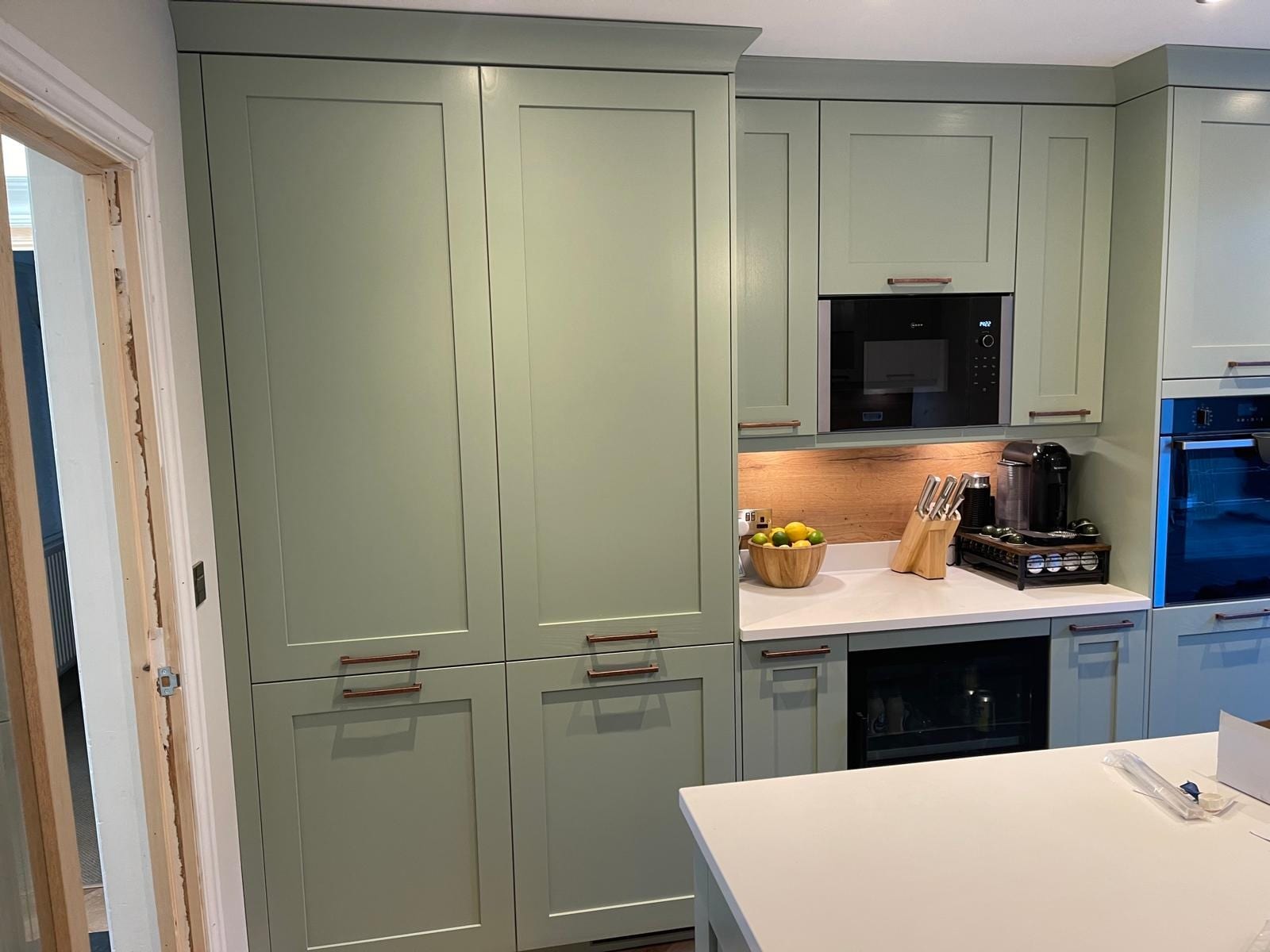 Sage green Shaker kitchen with island, coffee station and under-cabinet lighting